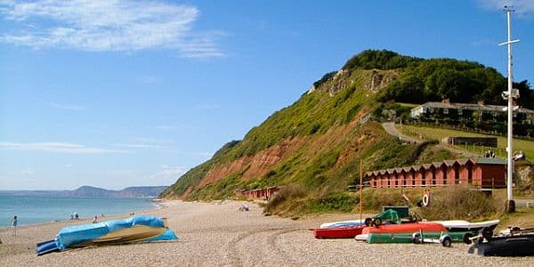 The seaside at Branscombe with boats on a pebble beach under a clear blue sky