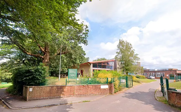 Exterior of Heathfield Community College in East Sussex with a large tree and pleasant weather