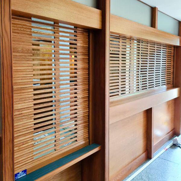 Open lath timber shutters at the reception of Wolfson College