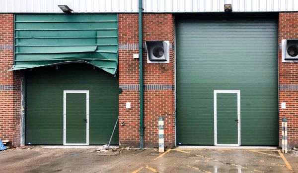 A pair of green roller shutters - one damaged