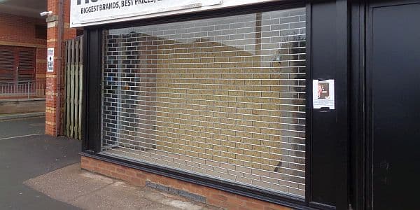 Roller grille behind the glass of a disused window display
